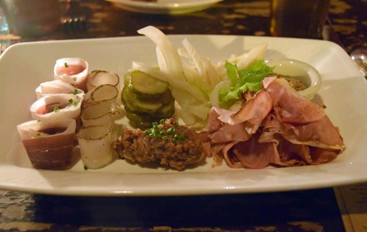 An assortment of cured meats & Pickles in the charcuterie plate